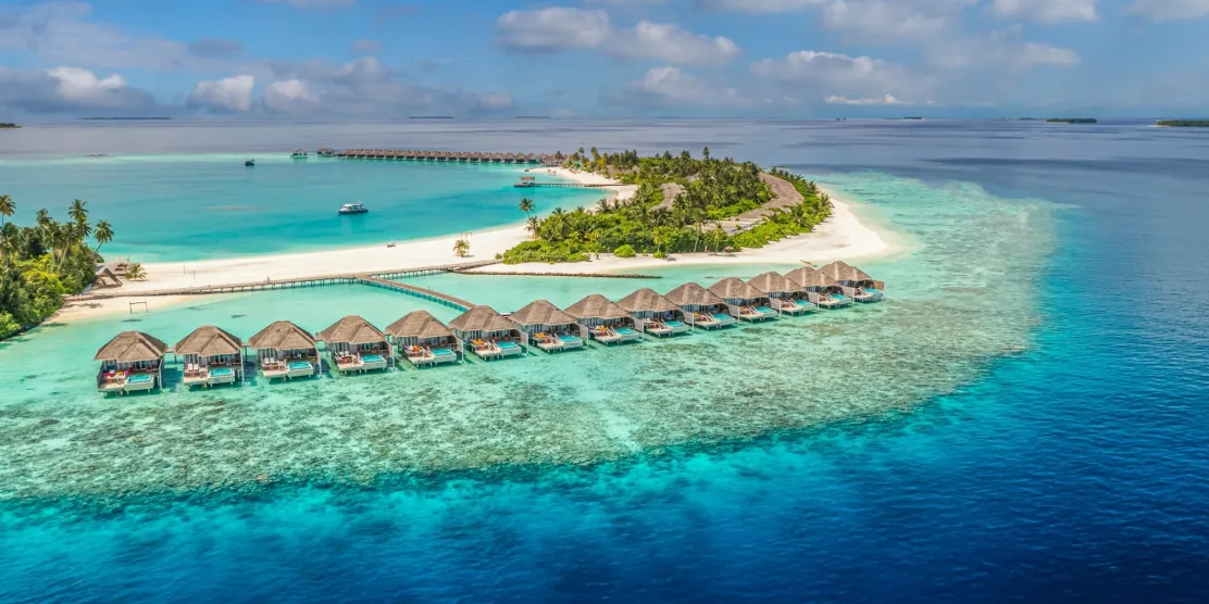 Maldives island resort in December with overwater villas and turquoise lagoon