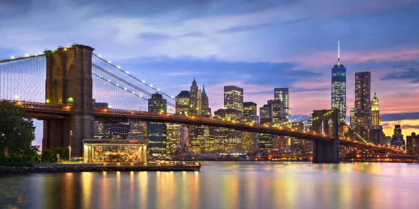 Brooklyn Bridge and the New York City skyline at sunset.